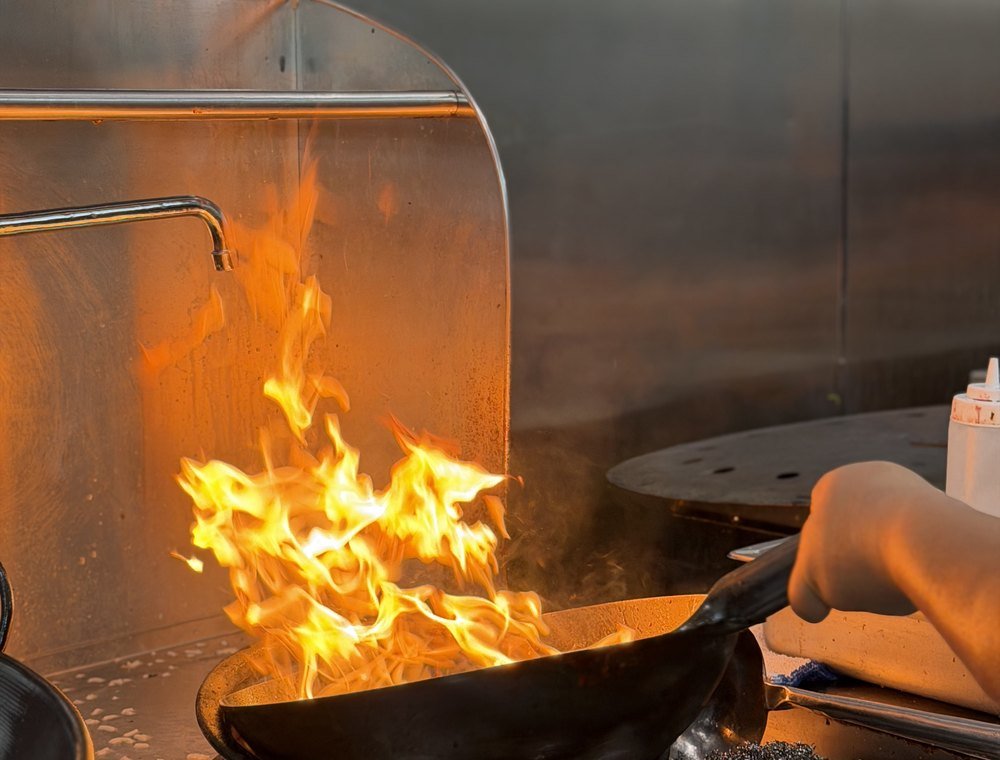 Flames rising from the kitchen wok